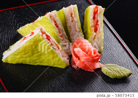 Triangular pieces. Japanese food, tasty of meal for lunch. Seafood. Sushi with eel, salmon, trout Triangular pieces. Japanese food, tasty of meal for lunch. Seafood. Sushi with eel, salmon, trout 58073415