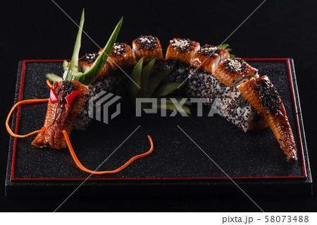 Sushi dragon with eel, cucumber and avocado on a black background. Japanese food, tasty of meal for Sushi dragon with eel, cucumber and avocado on a black background. Japanese food, tasty of meal for 58073488