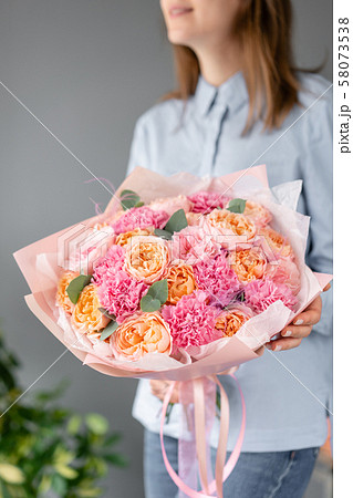 Multi color. Beautiful bouquet of mixed flowers in womans hands. the work of the florist at a flower Multi color. Beautiful bouquet of mixed flowers in womans hands. the work of the florist at a flower 58073538