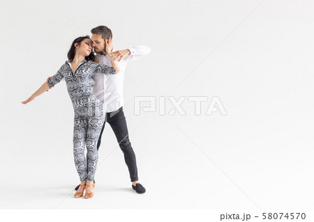 Social dance, kizomba, tango, salsa, people concept - beautiful couple dancing bachata on white Social dance, kizomba, tango, salsa, people concept - beautiful couple dancing bachata on white 58074570