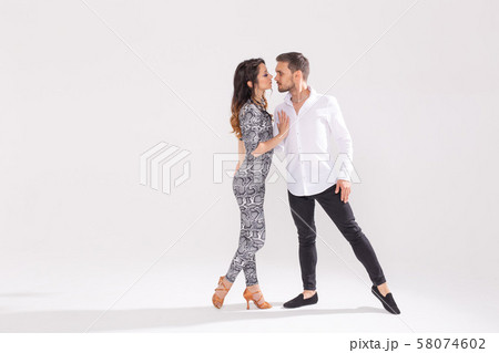 Young couple dancing latin dance bachata, merengue, salsa, kizomba. Two elegance pose over white 58074602
