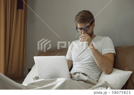 Man having cold spending time in his bed Man having cold spending time in his bed 58075823