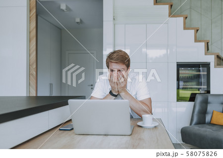 Man laughing at the messages he receiving 58075826