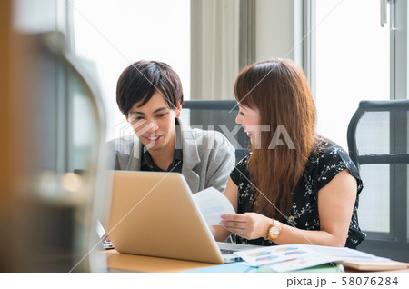 ビジネス デスクワークする若い男女 ビジネス デスクワークする若い男女 58076284