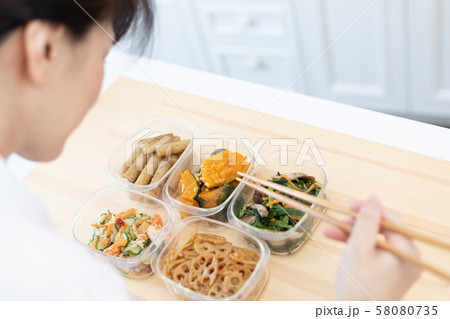 常備菜を詰める女性の手元 58080735