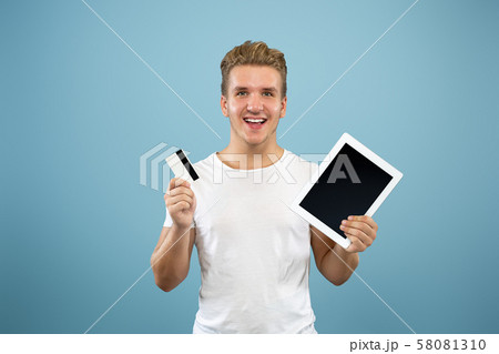 Caucasian young man's half-length portrait on blue background 58081310