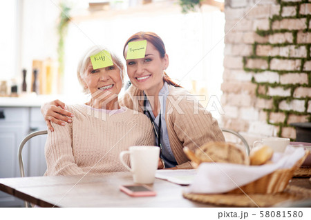 Caregiver hugging pensioner after playing words game 58081580