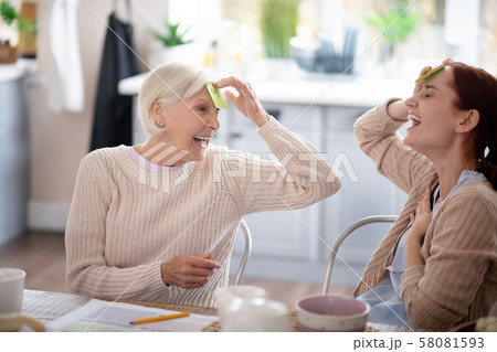 Laughing pensioner playing words game with nurse Laughing pensioner playing words game with nurse 58081593