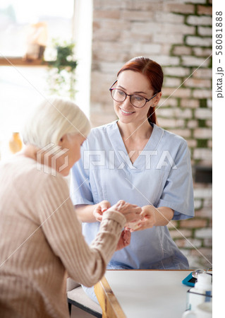 Medical attendant wearing glasses giving pills for patient Medical attendant wearing glasses giving pills for patient 58081888