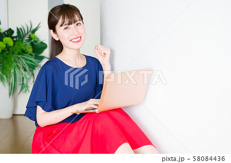 部屋でパソコンをつかう若い女性 部屋でパソコンをつかう若い女性 58084436