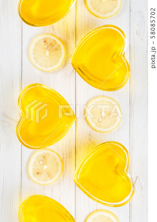 Yellow lemon jelly in heart shaped glass on white Yellow lemon jelly in heart shaped glass on white 58085702