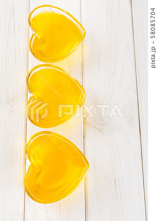 Yellow lemon jelly in heart shaped glass on white Yellow lemon jelly in heart shaped glass on white 58085704