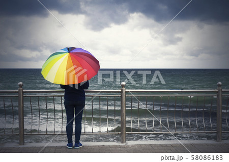 Young beautiful woman with colorful umbrella 58086183