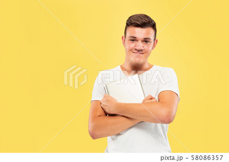 Caucasian young man's half-length portrait on yellow background Caucasian young man's half-length portrait on yellow background 58086357