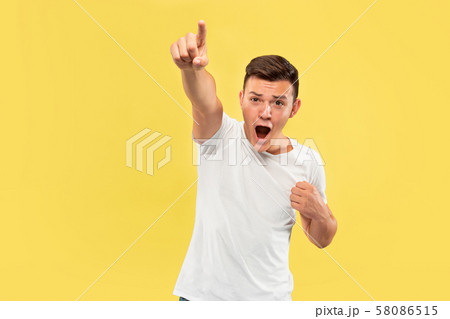 Caucasian young man's half-length portrait on yellow background Caucasian young man's half-length portrait on yellow background 58086515