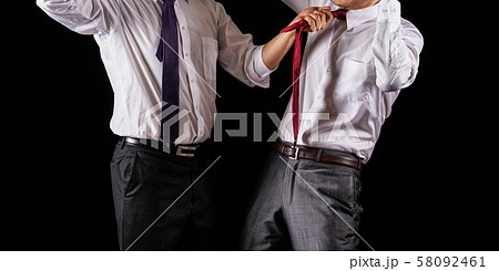 掴み合いのけんかをするビジネスマン 58092461