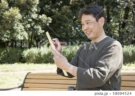 代々木公園で俳句を詠む中年男性 58094524