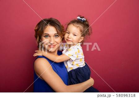 Cheerful mother and daughter smiling and having a hug. 58096318