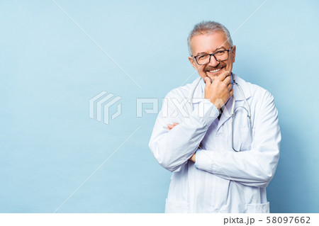 Cheerful mature doctor posing and smiling at camera, healthcare and medicine. Cheerful mature doctor posing and smiling at camera, healthcare and medicine. 58097662