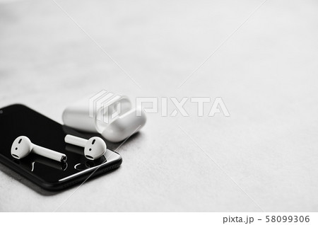 Wireless earphones with case and smartphone. Wireless earphones with case and smartphone. 58099306