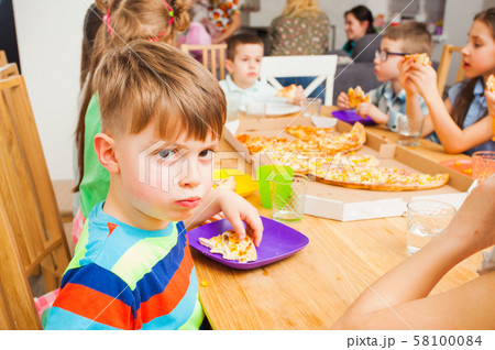 Children eating pizza on the kids meeting Children eating pizza on the kids meeting 58100084