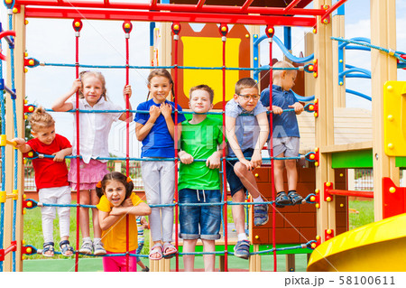 Children at school yard playground climbing together Children at school yard playground climbing together 58100611
