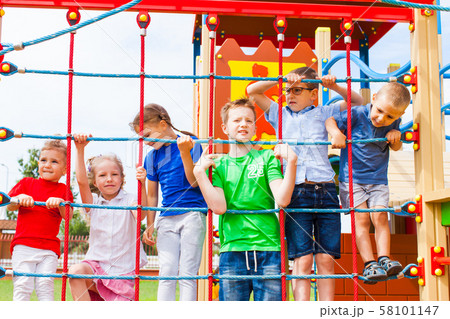 Group of children holding on climbing net Group of children holding on climbing net 58101147
