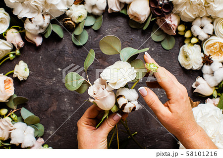Florist makes a bouquet, top view with hands Florist makes a bouquet, top view with hands 58101216