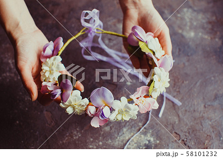 Woman's hands hold foam wreath with sprint flowers Woman's hands hold foam wreath with sprint flowers 58101232
