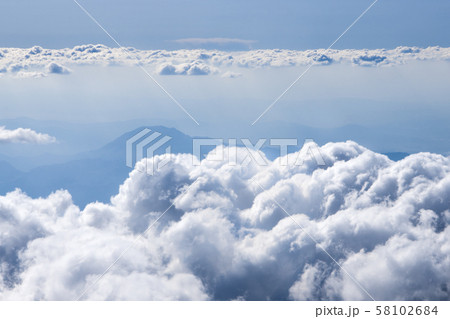 Fluffy clouds over the mountains view from the airplane window 58102684