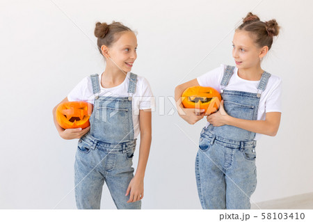 Happy Halloween, holidays and childhood concept - Cute little twins sisters girls with a pumpkins Happy Halloween, holidays and childhood concept - Cute little twins sisters girls with a pumpkins 58103410
