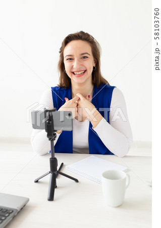 Blogging and vlog concept - young woman blogger talking on the camera Blogging and vlog concept - young woman blogger talking on the camera 58103760