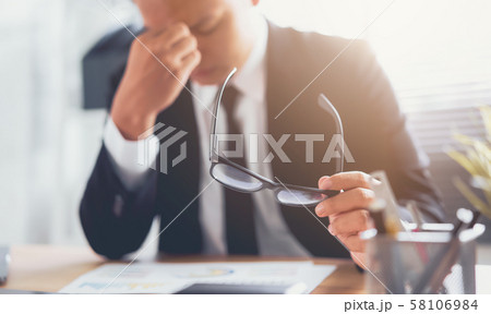 Businessman hand touching on eyes due to tiredness 58106984