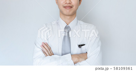 Business employee smiling in white shirt with arm crossed 58109361