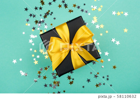 Gift box with yellow bow on green background with 58110632