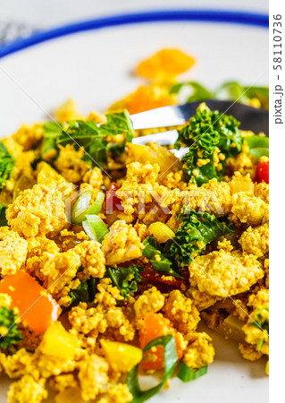 Tofu scramble with vegetables in a white plate. Tofu scramble with vegetables in a white plate. 58110736