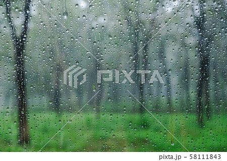 Raindrops on the window glass among the beautiful and refreshing green forest. The pure nature relieves the heart for humans. Raindrops on the window glass among the beautiful and refreshing green forest. The pure nature relieves the heart for humans. 58111843