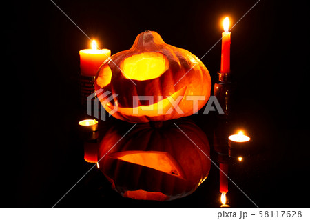 Image of one halloween pumpkin with burning mouths, candles on empty black background 58117628