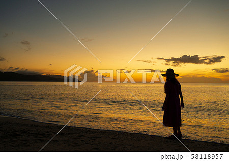 夕陽 サンセット 女性 夕焼け シルエットの写真素材