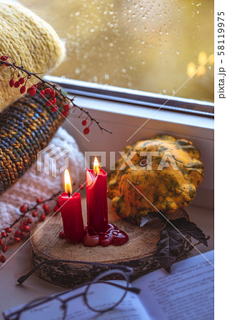 Autumn composition on a windowsill reading a book on a rainy evening. Autumn composition on a windowsill reading a book on a rainy evening. 58119975