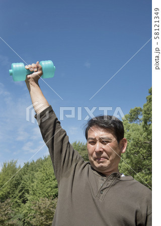 代々木公園でダンベルを使って筋トレをする中年男性 代々木公園でダンベルを使って筋トレをする中年男性 58121349