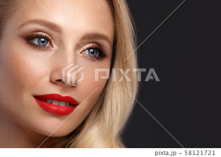Beautiful blonde in a Hollywood manner with curls, natural makeup and red lips. Beauty face and hair Beautiful blonde in a Hollywood manner with curls, natural makeup and red lips. Beauty face and hair 58121721