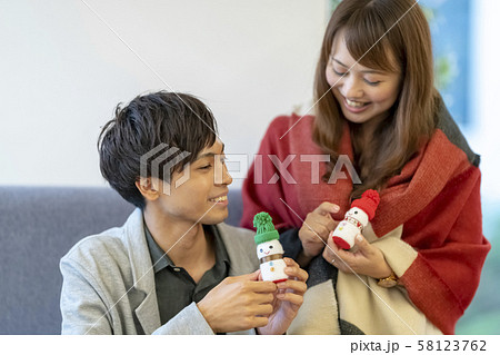 クリスマスに女性の手作りプレゼントを貰い喜ぶ若い男性 クリスマスに女性の手作りプレゼントを貰い喜ぶ若い男性 58123762