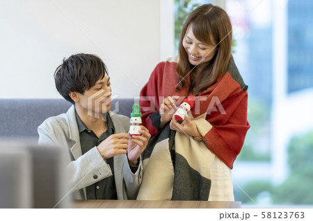 会社でクリスマスのプレゼントを渡され喜ぶ若い男性ビジネスマン 会社でクリスマスのプレゼントを渡され喜ぶ若い男性ビジネスマン 58123763