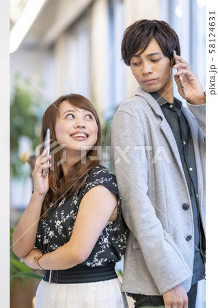 背中合わせでスマホで会話する男女二人 背中合わせでスマホで会話する男女二人 58124631