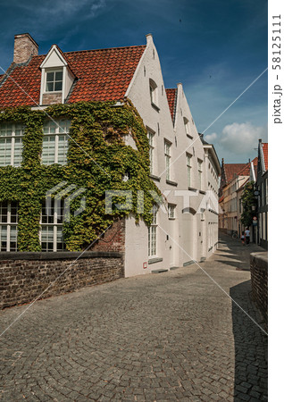 Bridge and brick buildings with creeper on canal of Bruges Bridge and brick buildings with creeper on canal of Bruges 58125111
