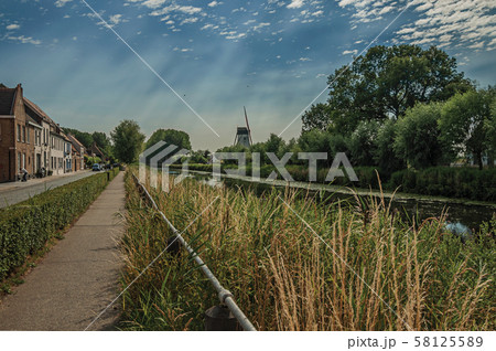 Sidewalk along canal with houses and bushes near Damme 58125589