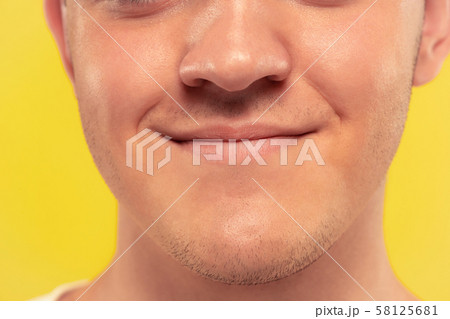 Caucasian young man's close up portrait on yellow background 58125681