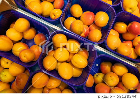 Yellow fresh delicious plum in blue plastic boxes at food market. May be used for agriculure Yellow fresh delicious plum in blue plastic boxes at food market. May be used for agriculure 58128544