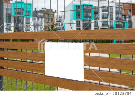 Close-up of blank white tablet on metal mesh gate Close-up of blank white tablet on metal mesh gate 58128784